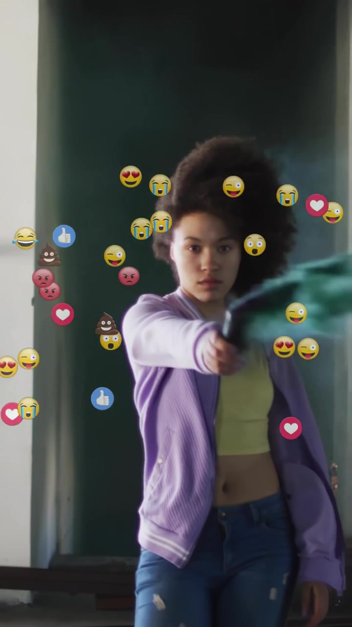 Woman holding emitter starting teal plume in doorway, sweeping camera, generating marketing emojis