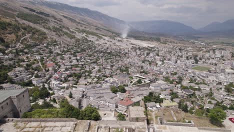 retroceso aéreo sobre la fortaleza de gjirokastër, vista de la ciudad patrimonio de la humanidad de la unesco