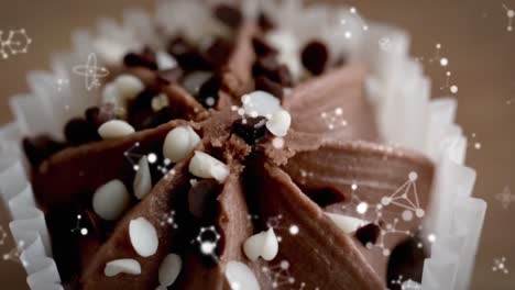 Animation-Von-Molekülen,-Die-über-Schokoladen-Cupcake-Fallen