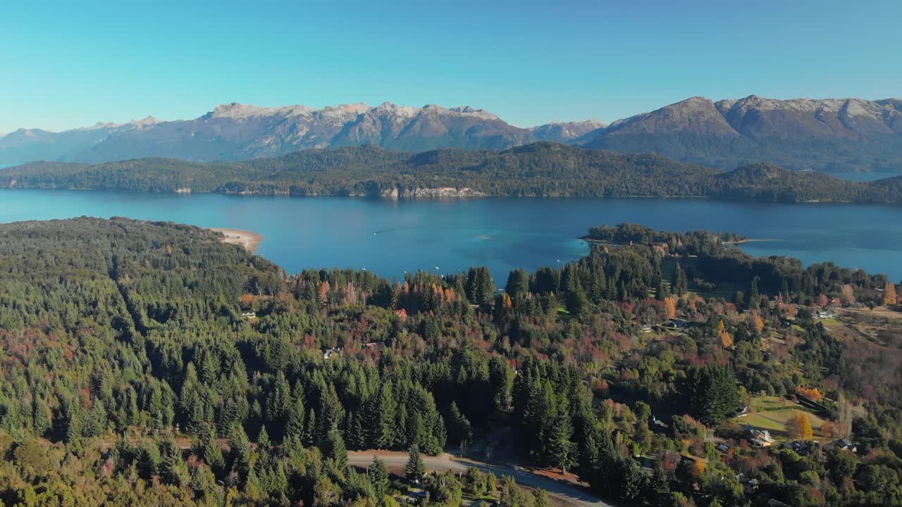 Veduta aerea di una foresta con case, un lago e le montagne delle Ande sullo sfondo