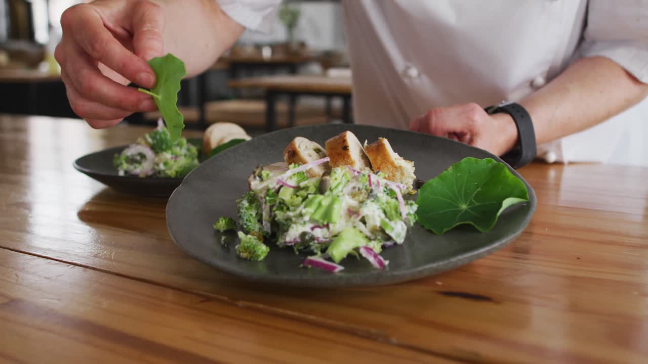 cocinera caucásica preparando un plato y sonriendo en una cocina