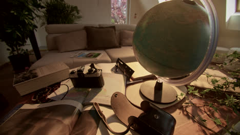 Desk setup with a globe, camera, and travel essentials