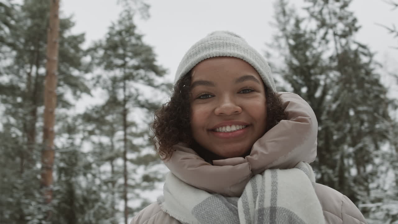 adolescente sonriente en el bosque de invierno