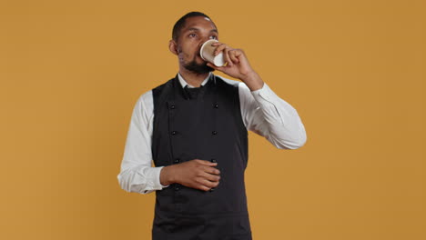 Restaurant-waiter-enjoying-a-cup-of-coffee-drink-on-his-work-break