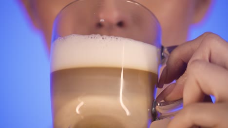 Woman-drinking-a-glass-of-beer-and-licking-her-lips