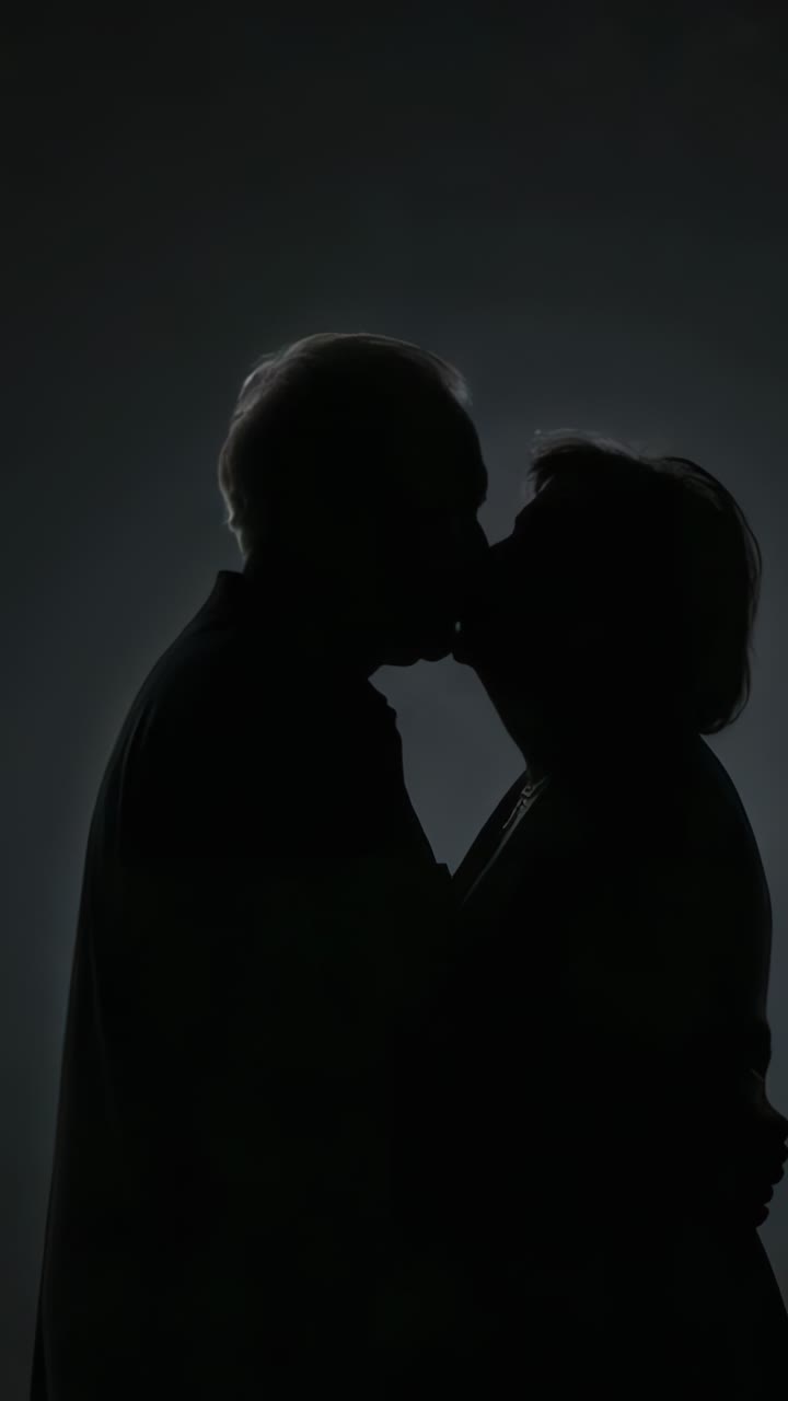 Vertical video: Pressing foreheads, senior couple kissing against gradient backdrop showing love