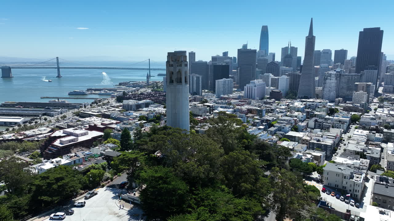 Coit Tower Overlooking The Downtown Skyline, San Francisco Bay, And San Francisco - Oakland Bay Bridge In California, USA. - aerial shot