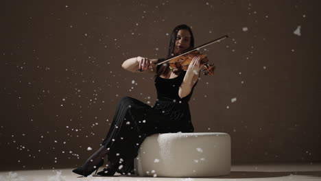 mulher tocando violino em um estúdio de inverno