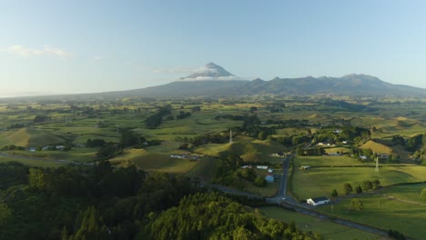 aerial, beautiful green farmland with mount taranki in background