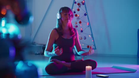 pregnant woman meditating by christmas tree