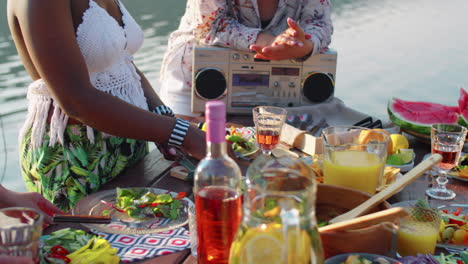 female friends cooking food for lake party and chatting