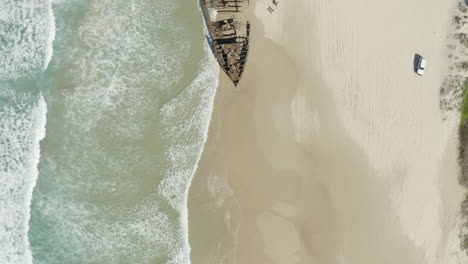 Vista-Superior-Amplia-Toma-De-Drones-Del-Viejo-Naufragio,-Ss-Maheno,-En-Una-Playa-De-La-Isla-Fraser,-Australia