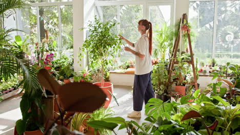 mujer cuidando plantas en un invernadero