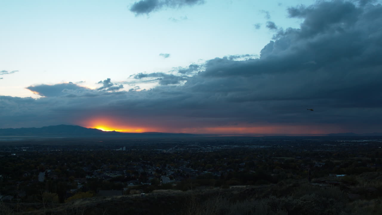 Dramatic Sunset over City with Helicopter