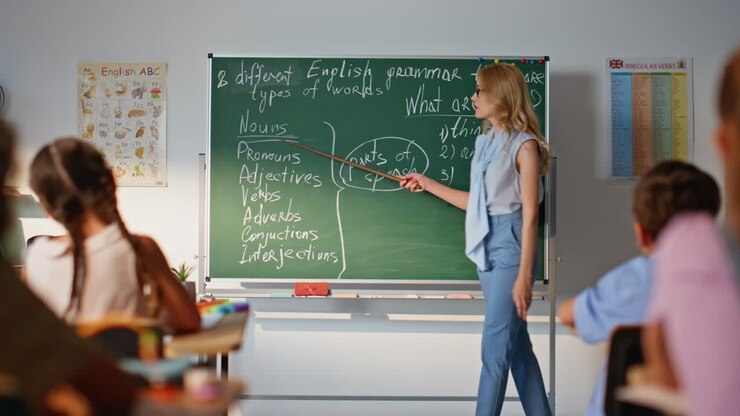 Educator pointing blackboard classroom explaining english to pupils school