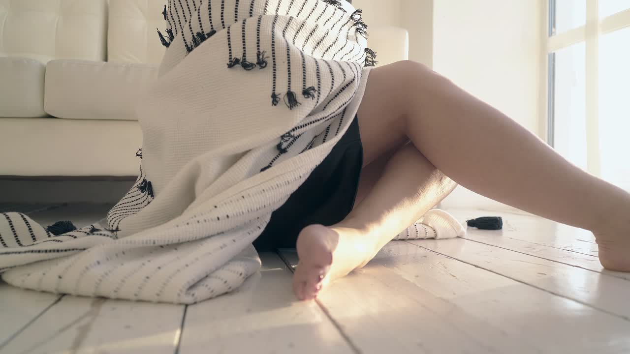 검은 옷을 입은 여자가 플레이드로 자신을  ⁇ 고 돌아다니고 있습니다.