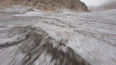 drone de carreras fpv volando a baja altitud sobre el glaciar marmolada, trentino en italia