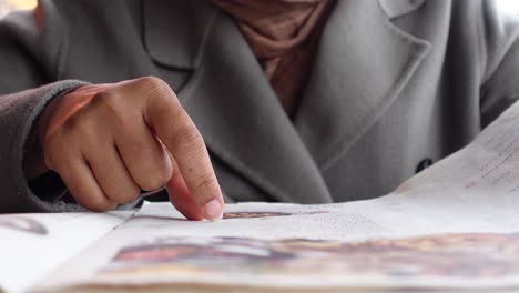 a woman points at the menu in a restaurant