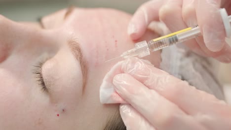 woman undergoing facial treatment at cosmetologist clinic