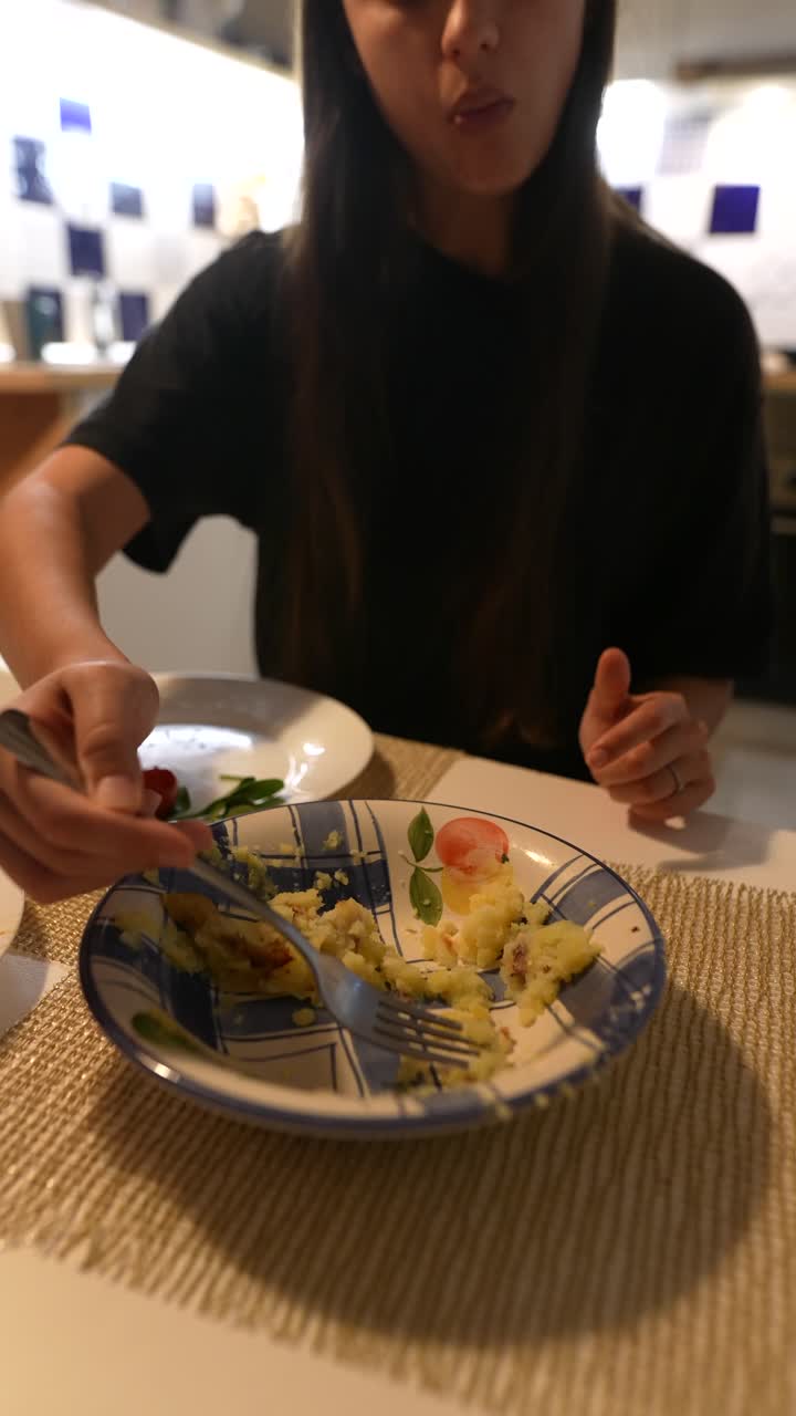 una mujer comiendo puré de patatas.