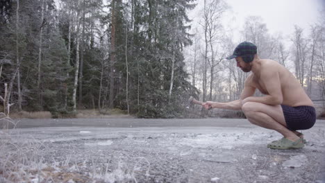 cámara lenta de 240 fps, un bañista de hielo frío cortando un lago para hacer un hoyo para bañarse