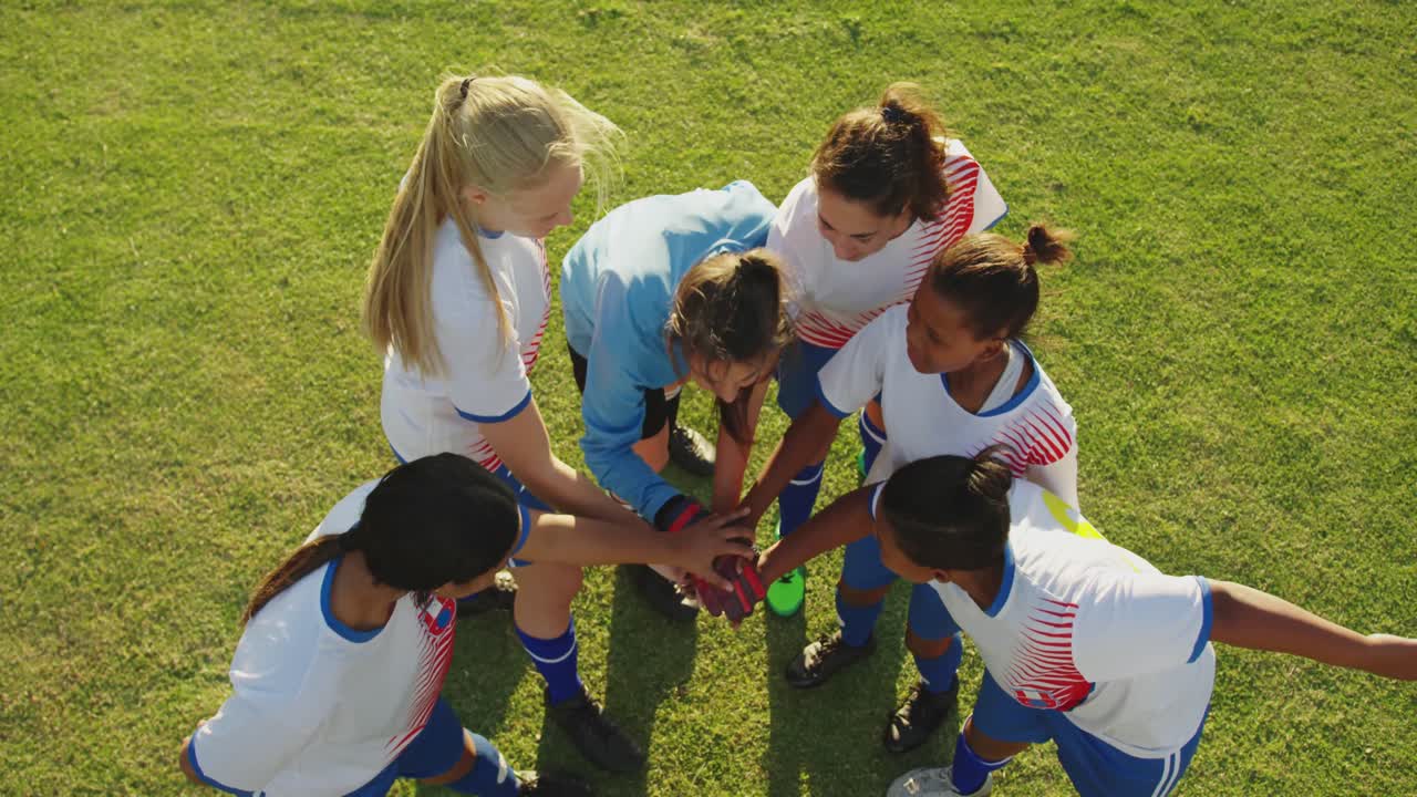 여자 축구 팀 이 축구장 에서 손 을 잡고 있다. 4k