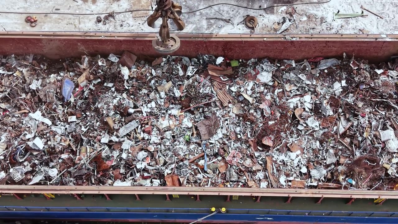 Cantiere edile con macchinari pesanti al lavoro per rimuovere detriti da una discarica nelle prime ore del mattino.