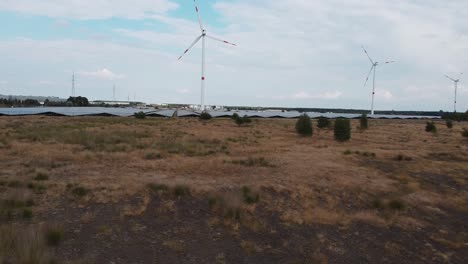 aerial shot of solar panels and wind turbines