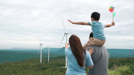 concept of progressive happy family enjoying their time at the wind turbine farm