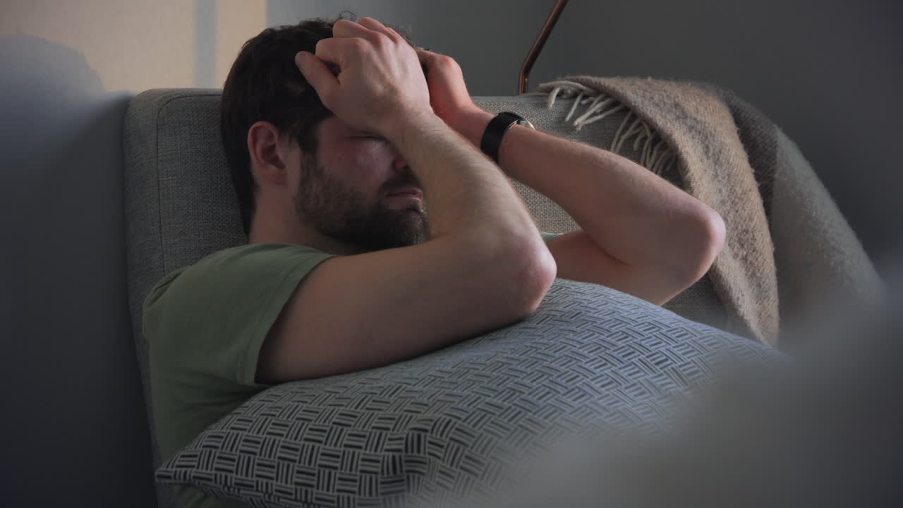 Man suffers from headache and stress, touching his temples