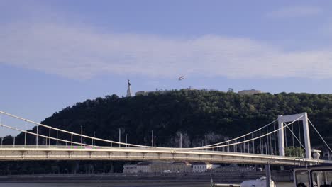 elisabeth bridge over danube river with liberty statue on citadella on gellert hill in budapest, hungary. - wide shot