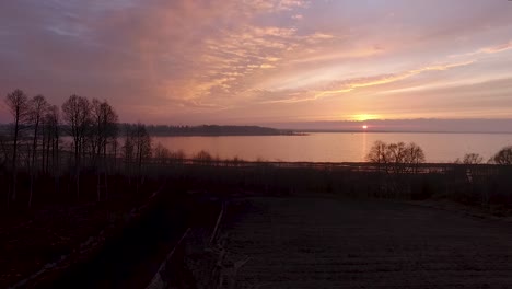 lake burtnieks in late autumn red sky sunset aerial wide view wit tree silhouette