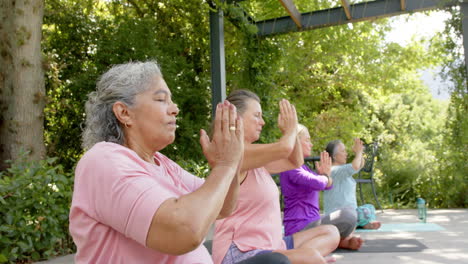 Mujer-Birracial-Mayor-Y-Mujeres-Caucásicas-Practicando-Yoga-Al-Aire-Libre