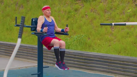 anciano abuelo de 80 años de edad entrenamiento deportivo abdominal ejercicio de cardio en el patio de recreo