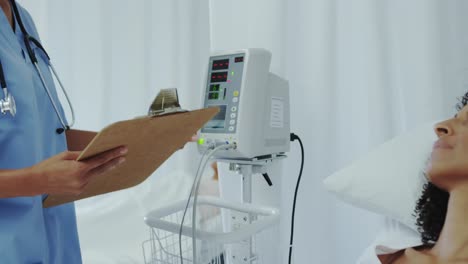 vista lateral de una mujer médica afroamericana hablando con una paciente femenina en el pabellón del hospital 4k