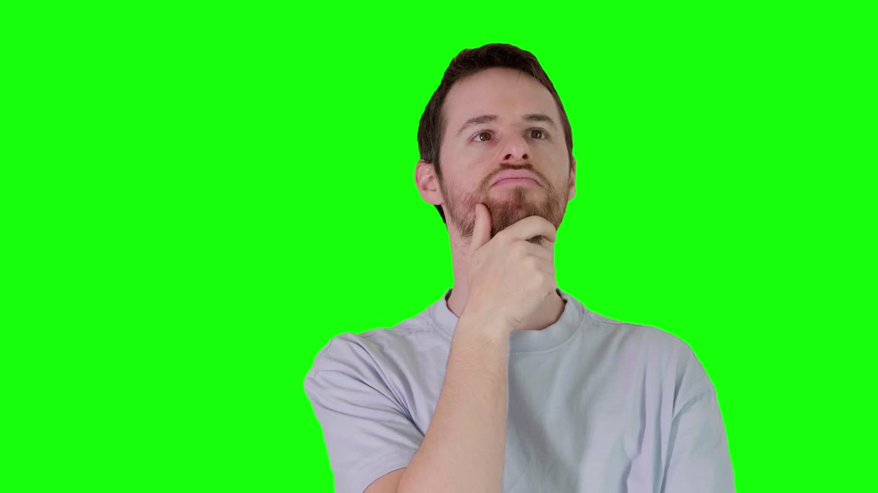 Man in grey t-shirt thinks deeply strokes short beard, points upward and nods in agreement . Shot against green screen. 9 sec clip