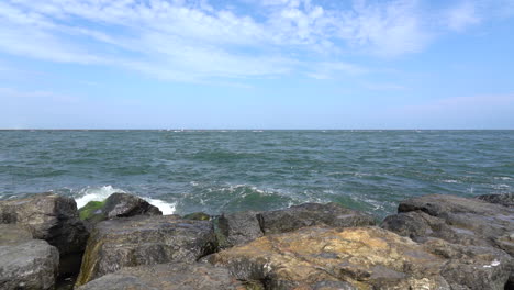 the waves from the ocean breaking over the rocks on the shore