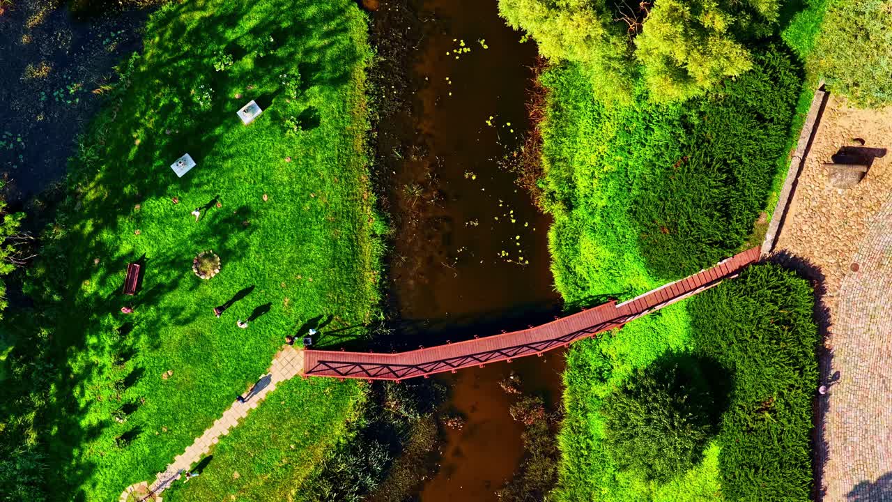 Aerial view of green park, bridge, river in Jaunpils, Latvia, peaceful scene