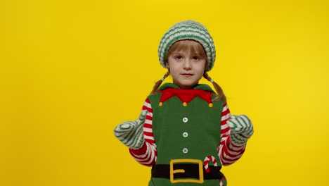 kid girl in christmas elf santa helper costume dancing, fooling around. new year holiday celebration