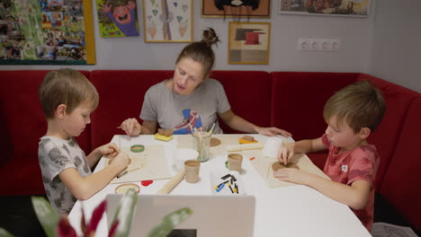 mother and sons at home taking part in a remote clay workshop during pandemic