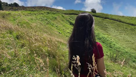 Beautiful-Women-Sitting-Peacefully-In-Long-Grass-On-Hill-Overlooking-Lagoon-In-Costa-Rica-4K