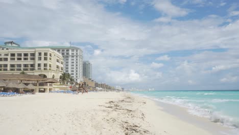 Empty-Caribbean-Beach-with-Resorts-and-calm-sea-waves