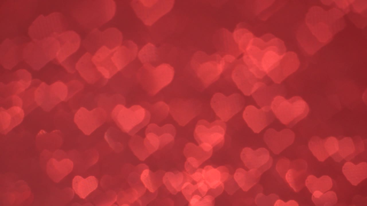 el bokeh en forma de corazón se mueve cíclicamente sobre un fondo rojo.