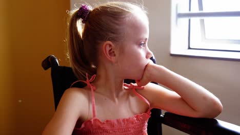 niña discapacitada mirando por la ventana en el aula