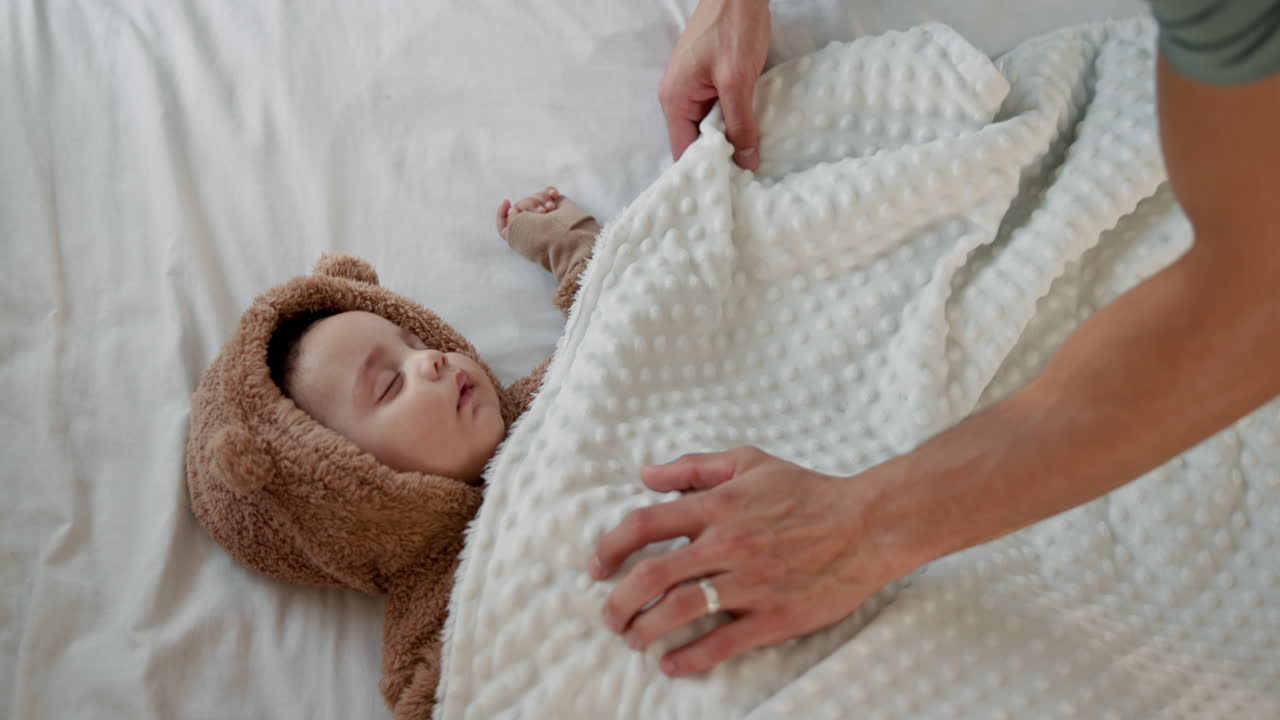 Un padre mette a letto il suo bambino.