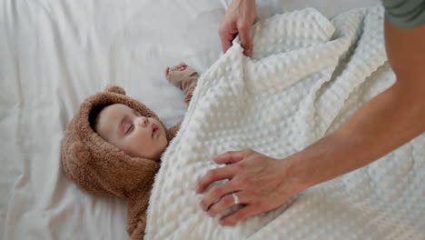 un padre coloca a su bebé en la cama