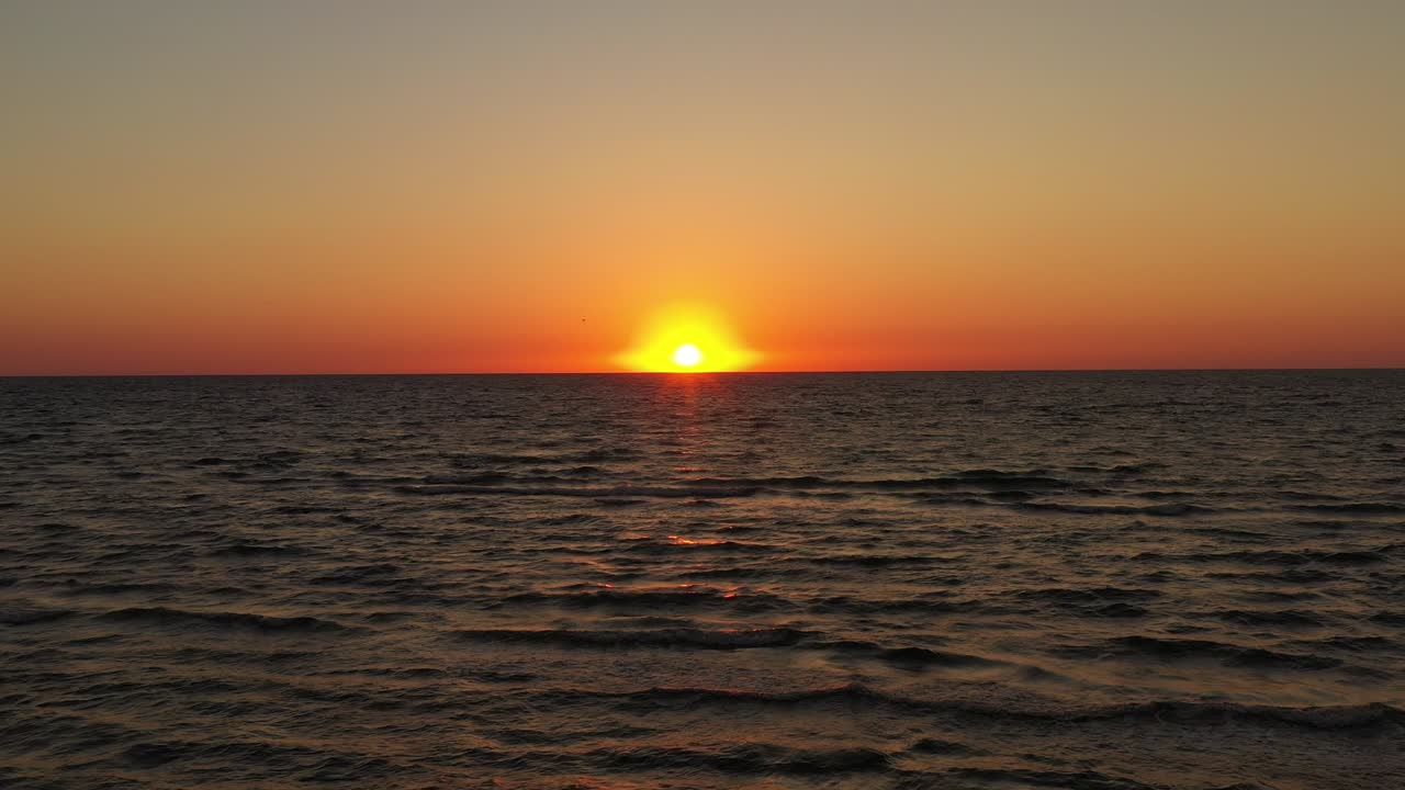 해수면 위를 날아다니는 드론, 해수면에서 해가 지거나 해가 뜨는 오렌지색 반사, 아침에 열대 풍경, 휴식, 자연 및 여름 휴가 개념.