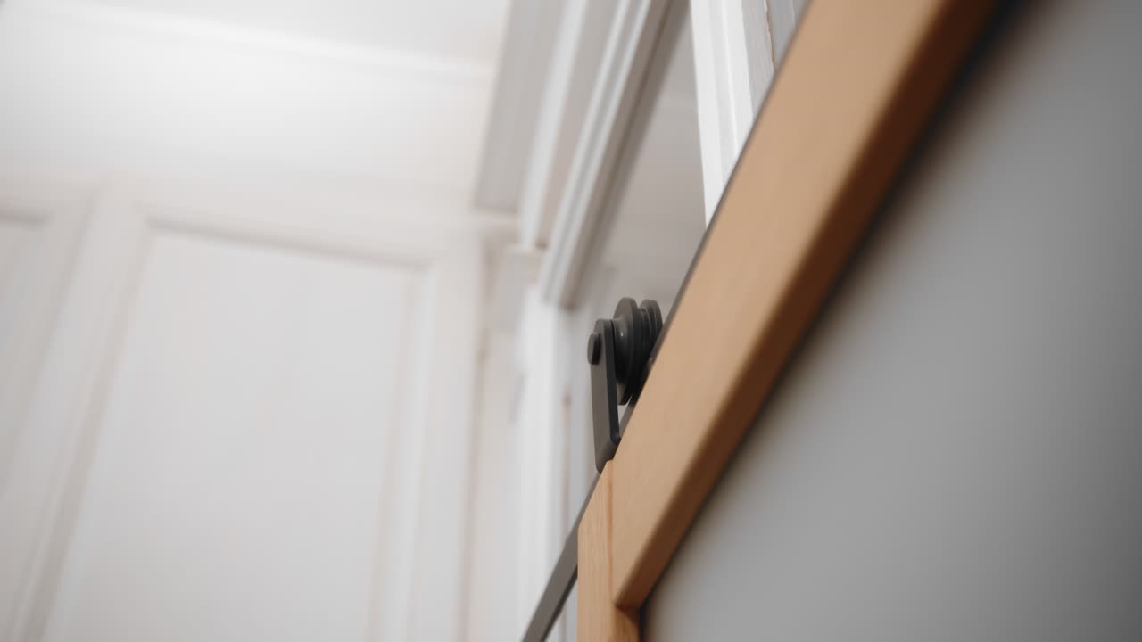 colgadores deslizantes de puertas de granero rodando en la vía mientras se cierran