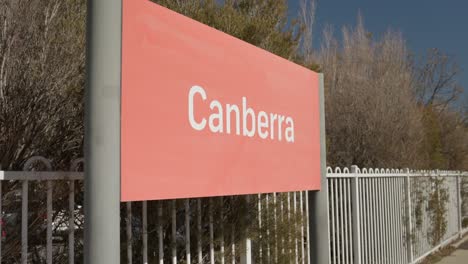 the canberra sign on the train station platform in the afternoon light, captured in slow motion