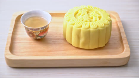 saveur de crème pâtissière de gâteau de lune chinois avec thé sur plaque de bois